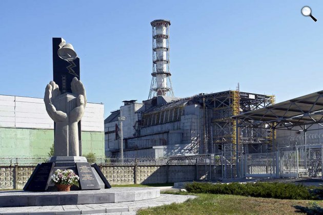 A mentés és a mentesítés résztvevőinek emlékműve a szarkofággal, Csernobil (Fotó: Wikipédia)
