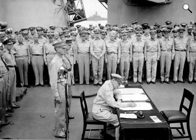 MacArthur aláírja a japán fegyverszüneti egyezményt a USS Missouri fedélzetén, 1945. szeptember 2. (Fotó: Wikimédia)