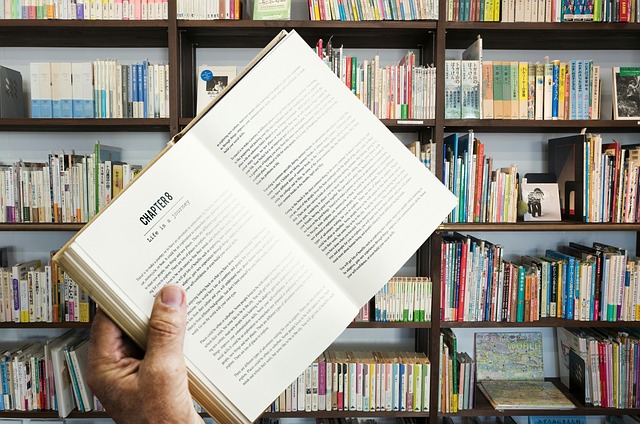 Egy nő könyvet olvas egy könyvtárban (Fotó: Pixxabay)