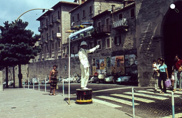 Vespa robogók parkolnak a Via Pianán, miközben rendőr irányítja a forgalmat, jobbra a Porta del Loco, San Marino, 1967 (Fotó: Fortepan/LHM)