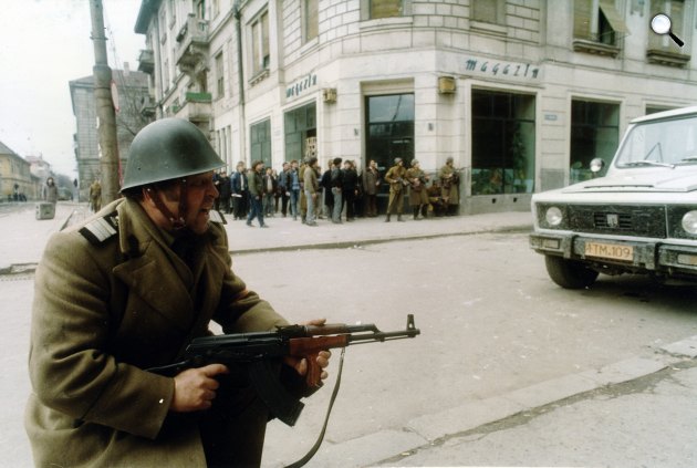 A romániai forradalom idején fegyveres katona Piața Libertății (Jenő herceg tér), jobbra a Városháza utca (Strada Emanoil Ungureanu), balra a háttérben a Strada Coriolan Brediceanu (Széchenyi utca), 1989 (Fotó: Fortepan)